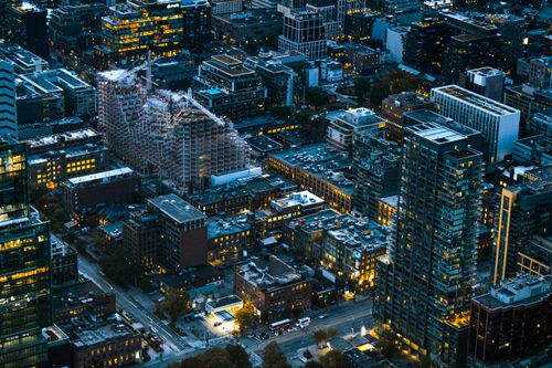 Free Aerial view of Toronto's urban skyline at twilight, featuring tall buildings and city lights. Stock Photo