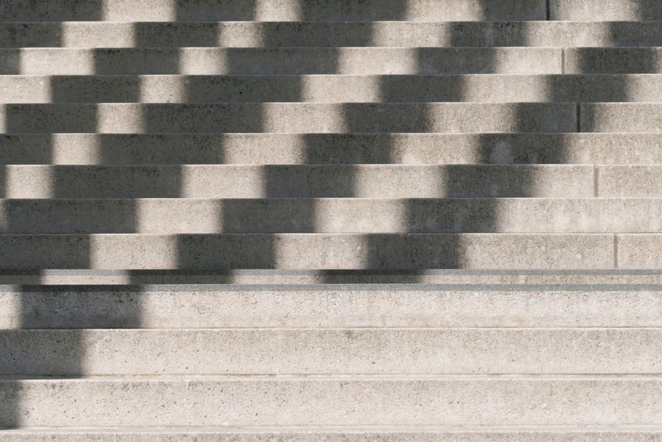 Capture of symmetrical concrete stairs in sunlight, showcasing shadows in Berlin, Germany.