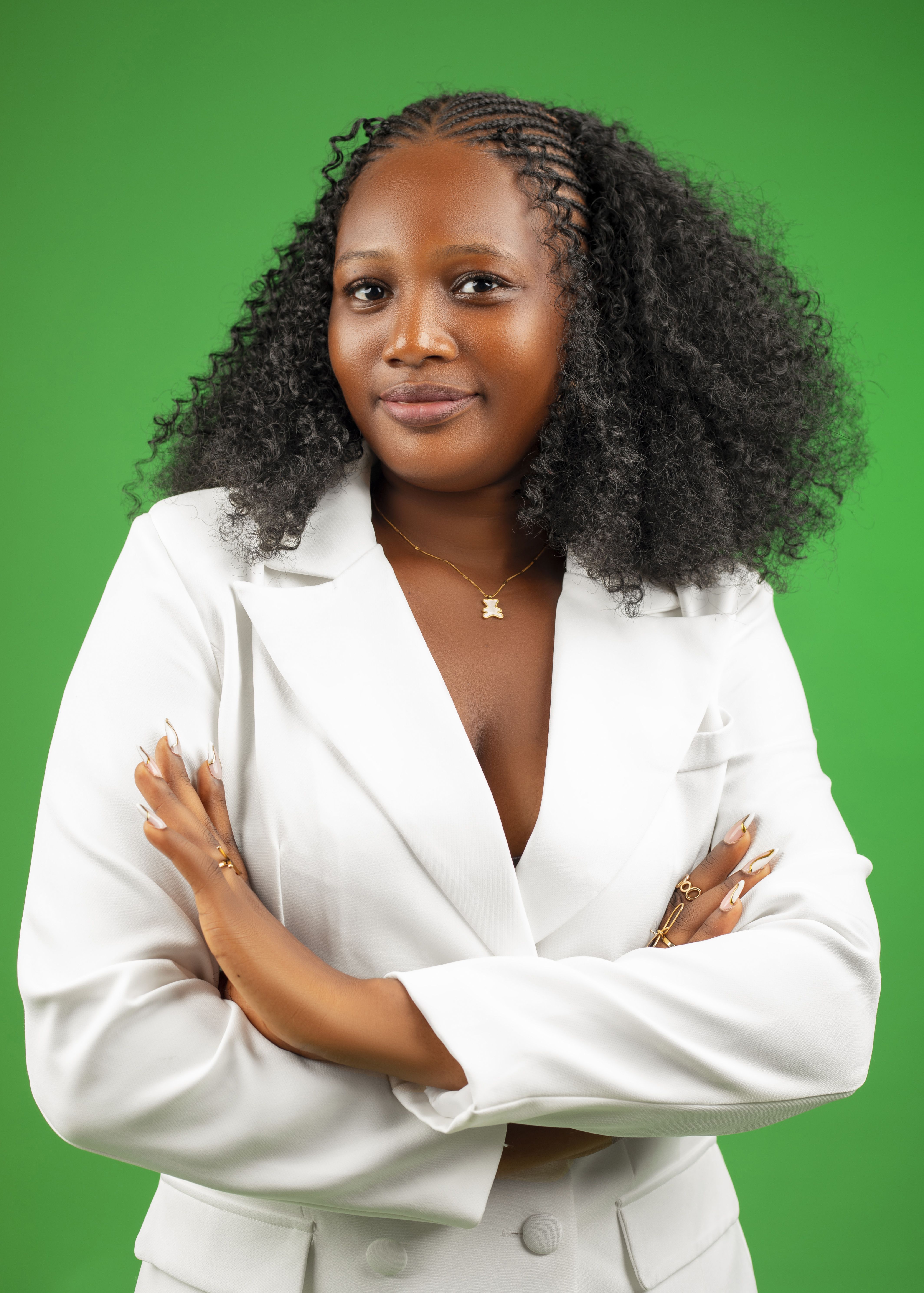 Portrait of a confident businesswoman in a white suit on a green background.