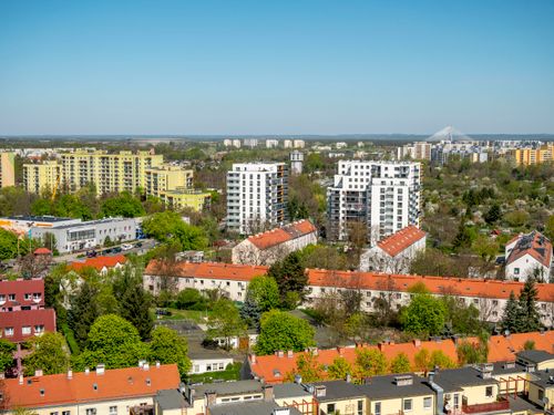 Free Aerial view of Wrocław showcasing residential buildings and green landscapes under a clear sky. Stock Photo