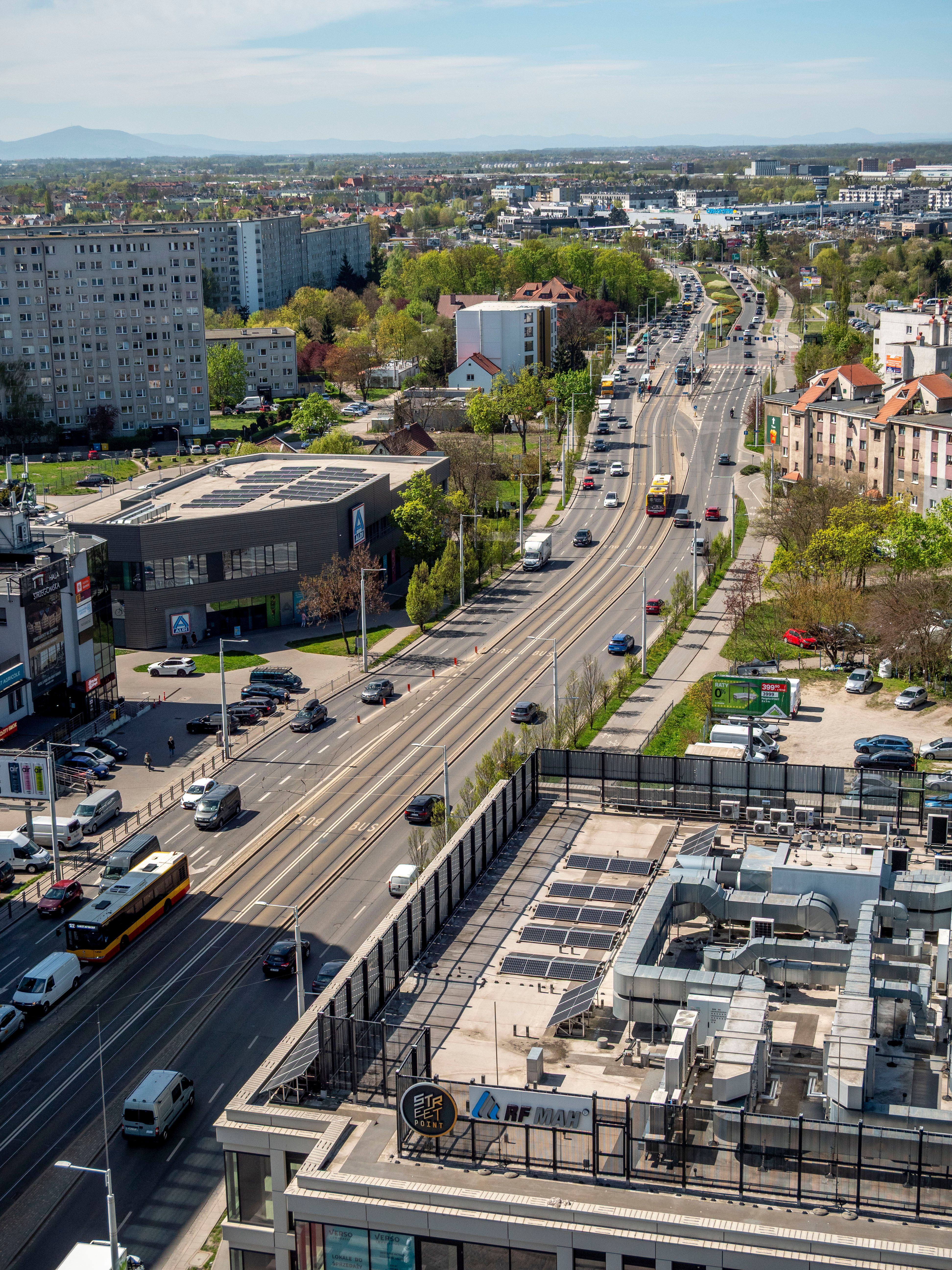 Aerial cityscape of Wrocław featuring roads, buildings, and green areas.