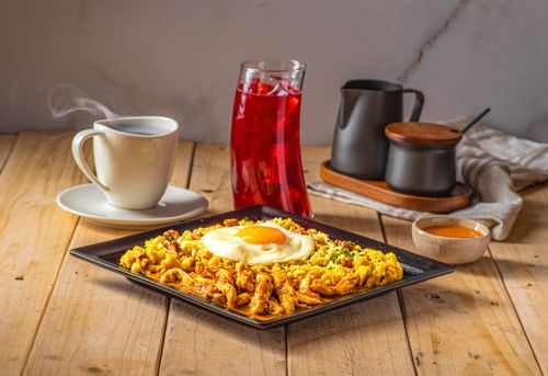 Free A mouthwatering Ecuadorian breakfast featuring scrambled eggs, chicken, and coffee served in a cozy Quito setting. Stock Photo
