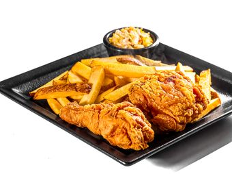 Crisp fried chicken with fries and slaw on a dark tray — photo by Cristian Arteaga on Pexels