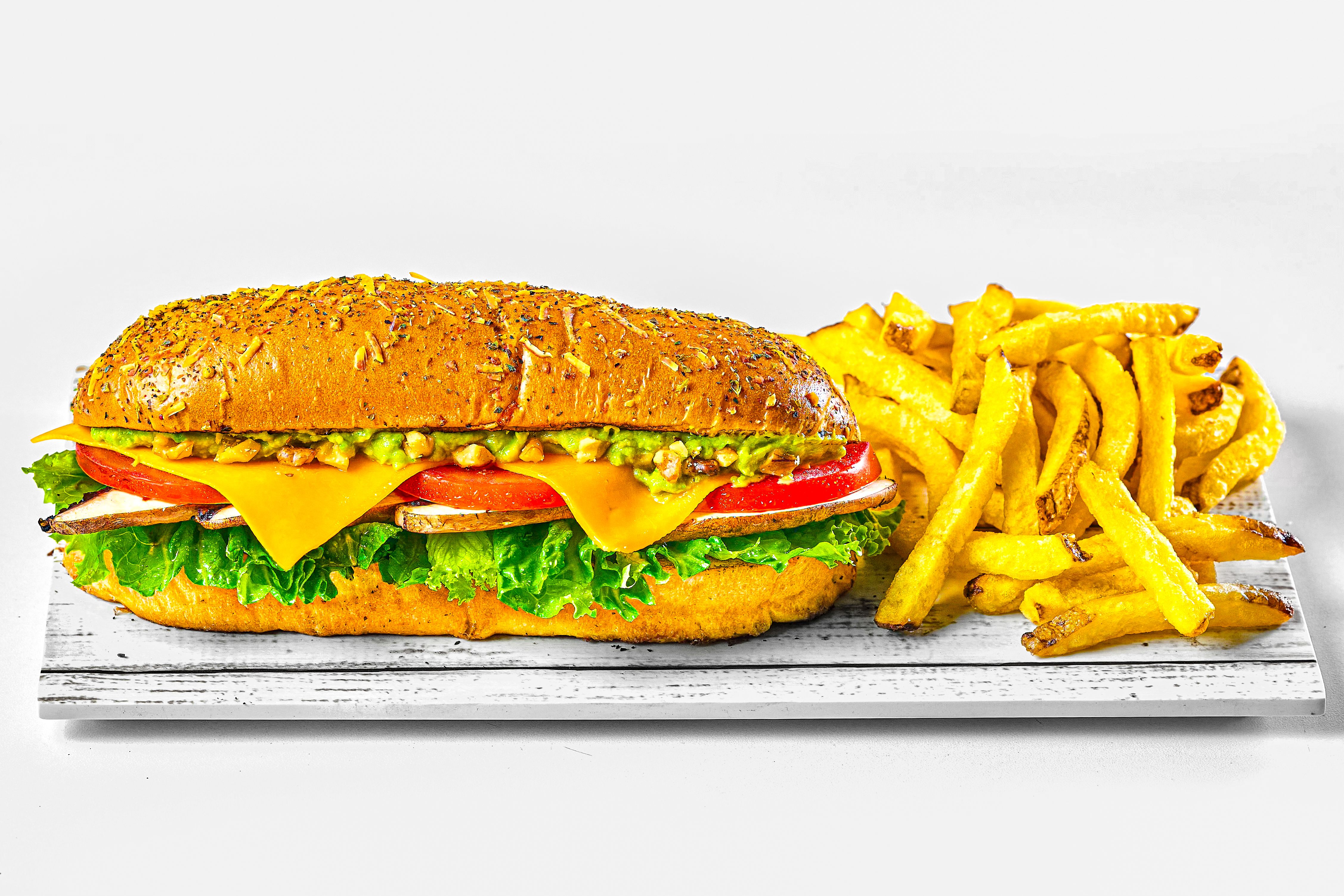 Delicious vegetarian sandwich with cheese and fresh veggies served with crispy fries.