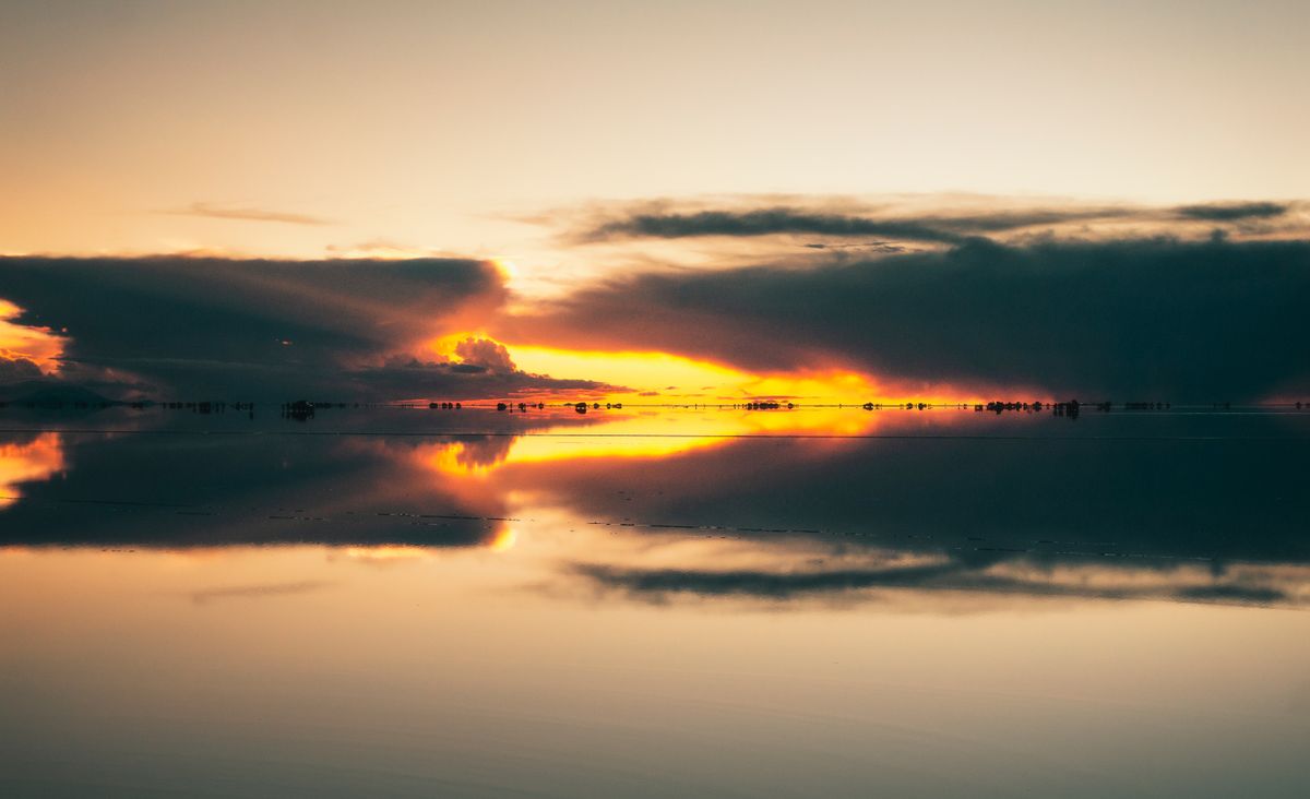 The Salar de Uyuni's mirror effect — sky and salt fusing into a spatial disorientation no wide-angle lens replicates.