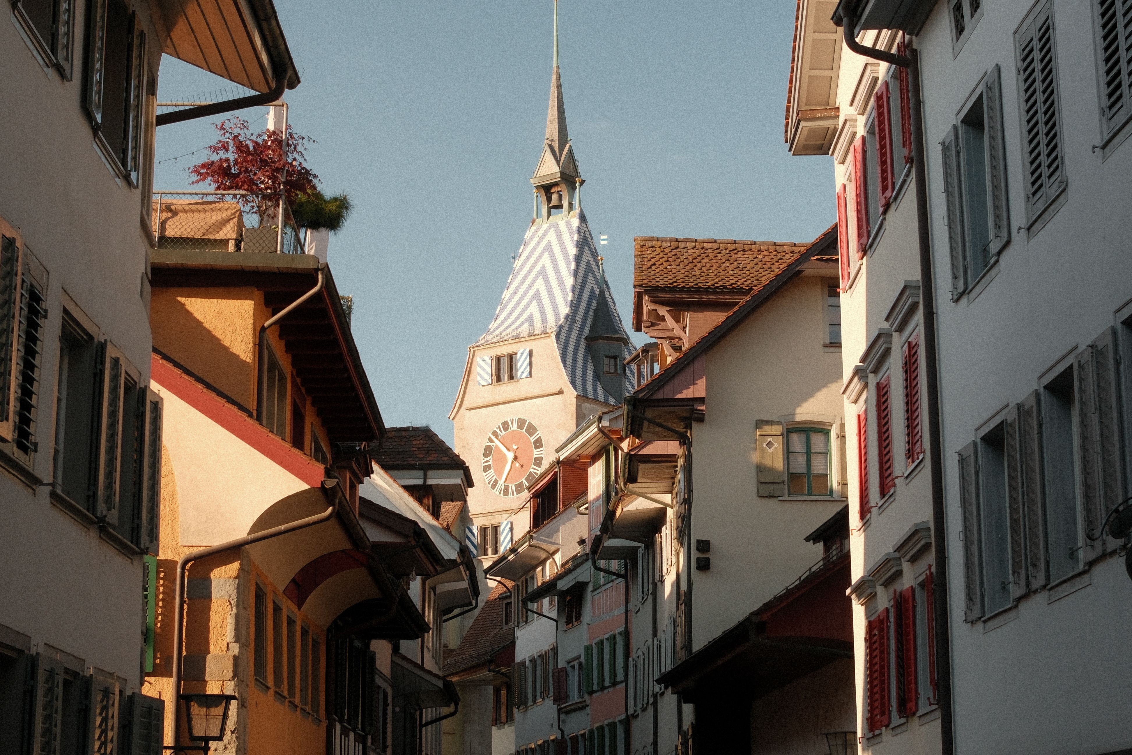 Discover the picturesque street view in Zug, Switzerland featuring the historic Zytturm tower.