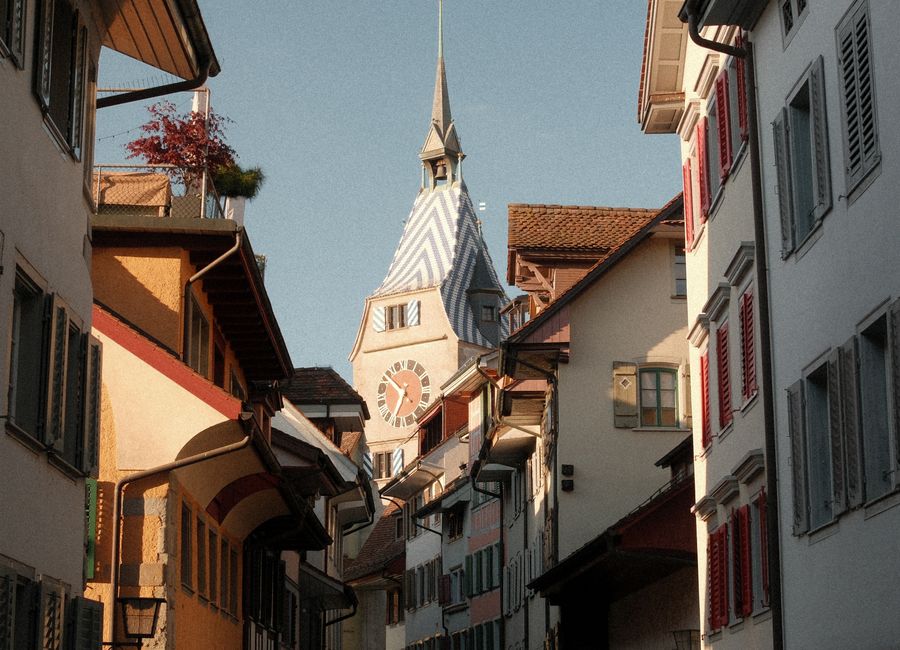 Discover the picturesque street view in Zug, Switzerland featuring the historic Zytturm tower.