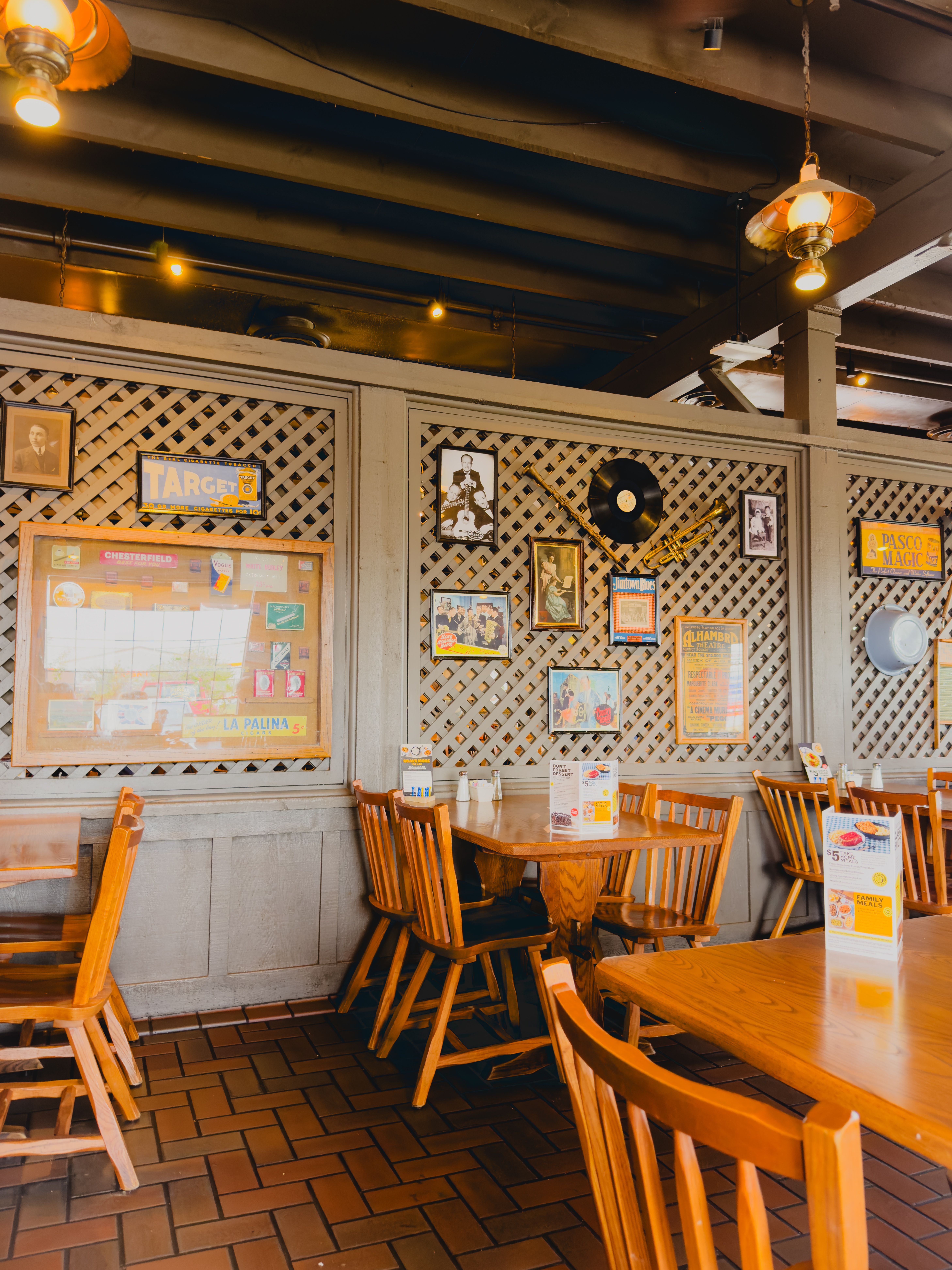 Charming restaurant interior featuring wooden chairs and vintage wall decor.