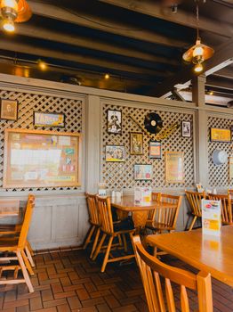 Charming restaurant interior featuring wooden chairs and vintage wall decor.