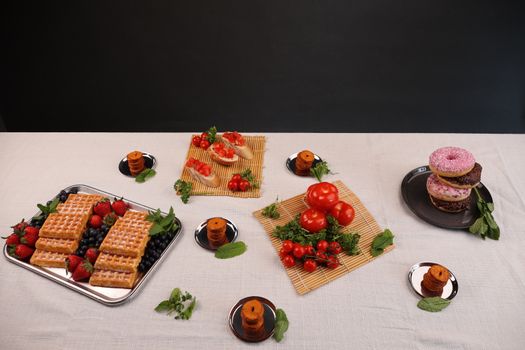 A beautifully presented assortment of waffles, donuts, and fresh produce at a Berlin event.