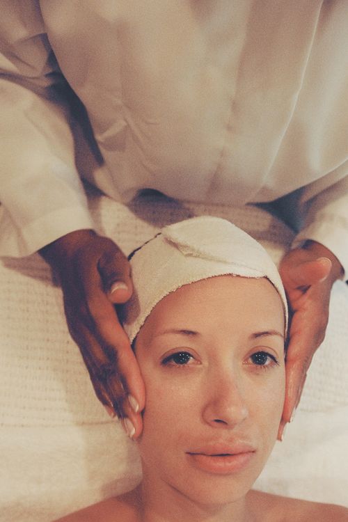 Free A woman receives a calming facial massage at a spa, promoting relaxation and skincare wellness. Stock Photo