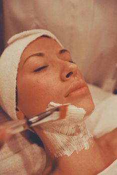 Close-up of a woman getting a soothing facial treatment at a spa for relaxation.