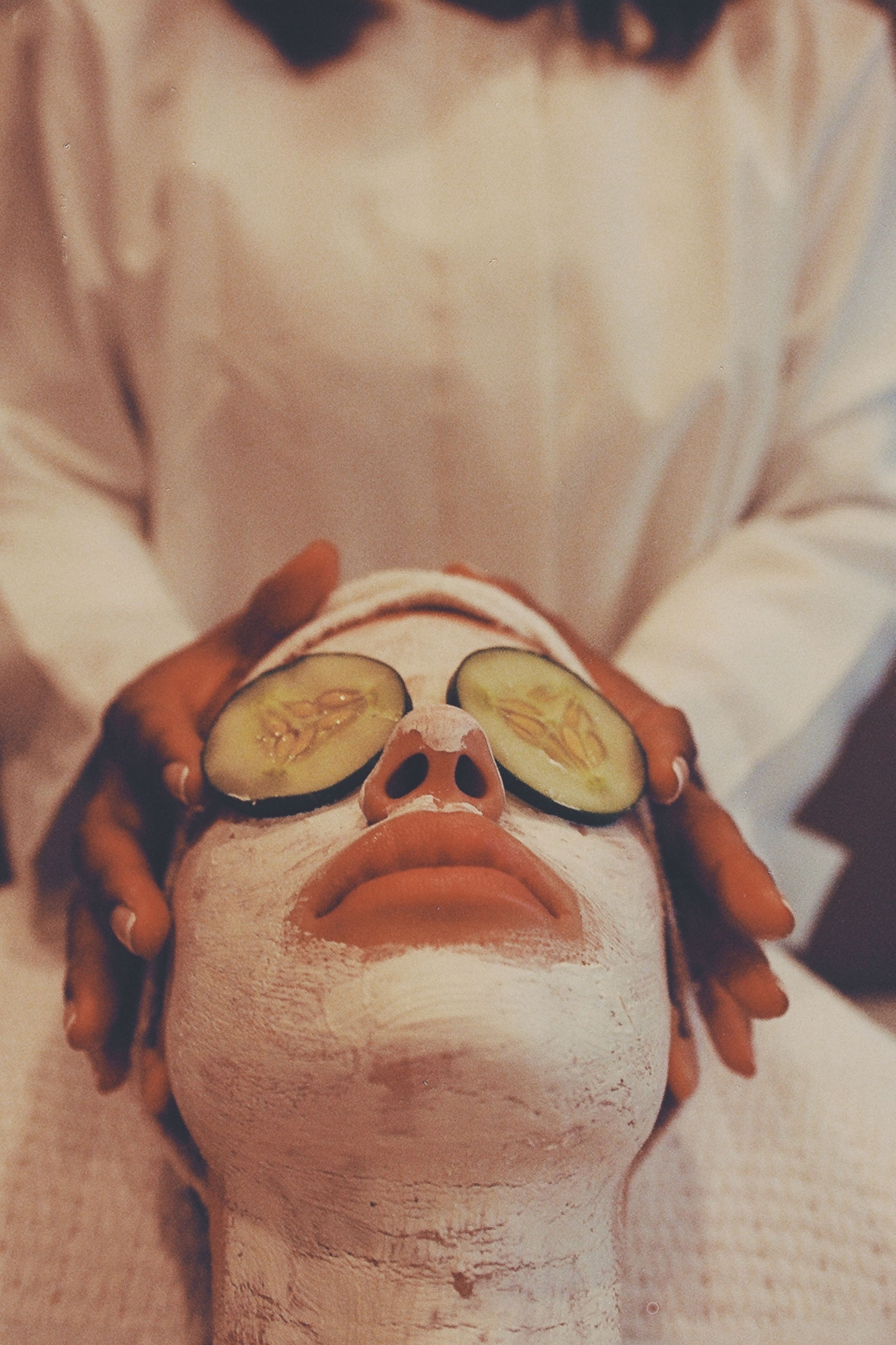 Um tratamento facial relaxante de spa com máscara de pepino para rejuvenescimento e relaxamento.
