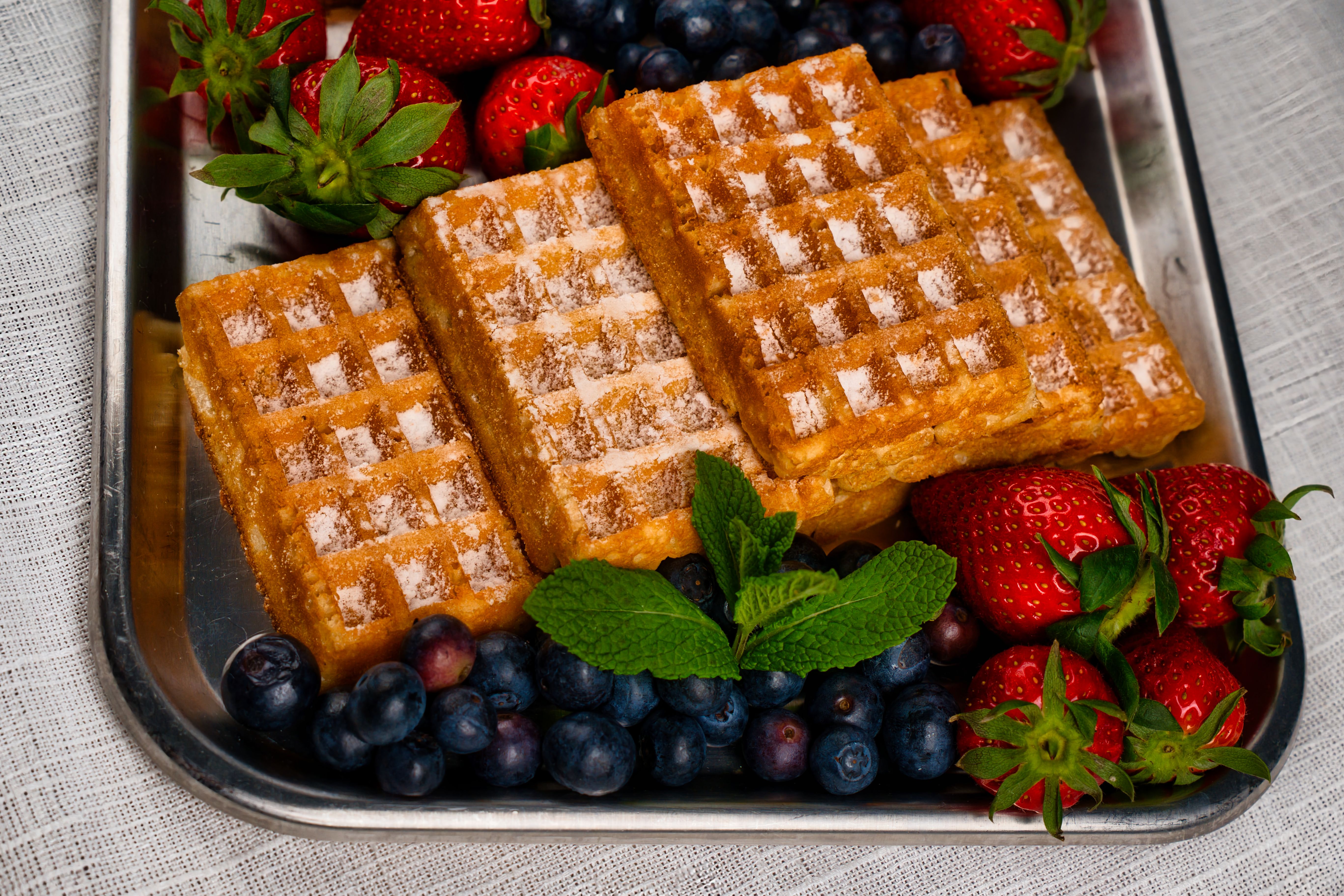 Toasted frozen blueberry waffles with syrup on a white plate