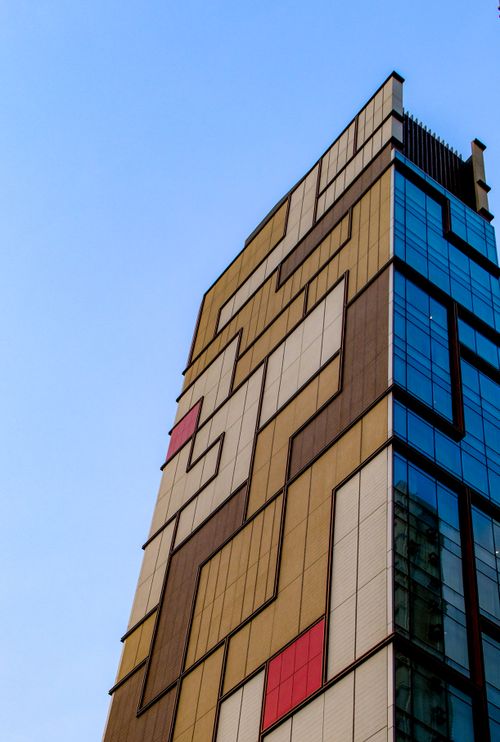 Free Angular view of a unique geometric facade building in Kowloon, Hong Kong, under a clear blue sky. Stock Photo