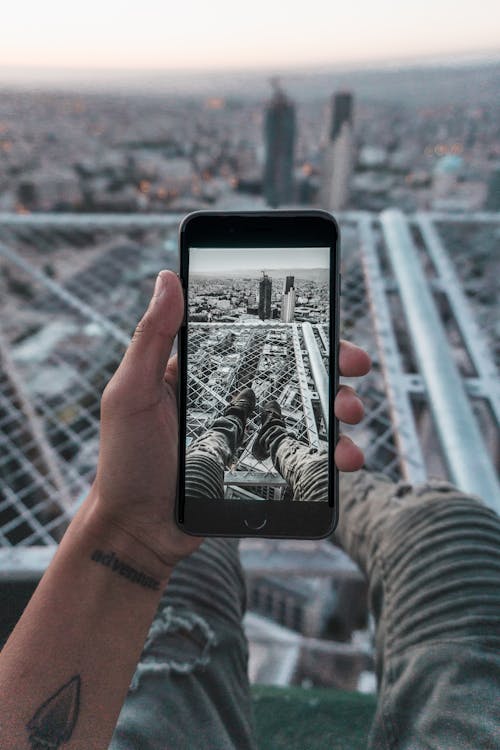 Gratis Orang Yang Memegang Iphone Hitam Foto Stok
