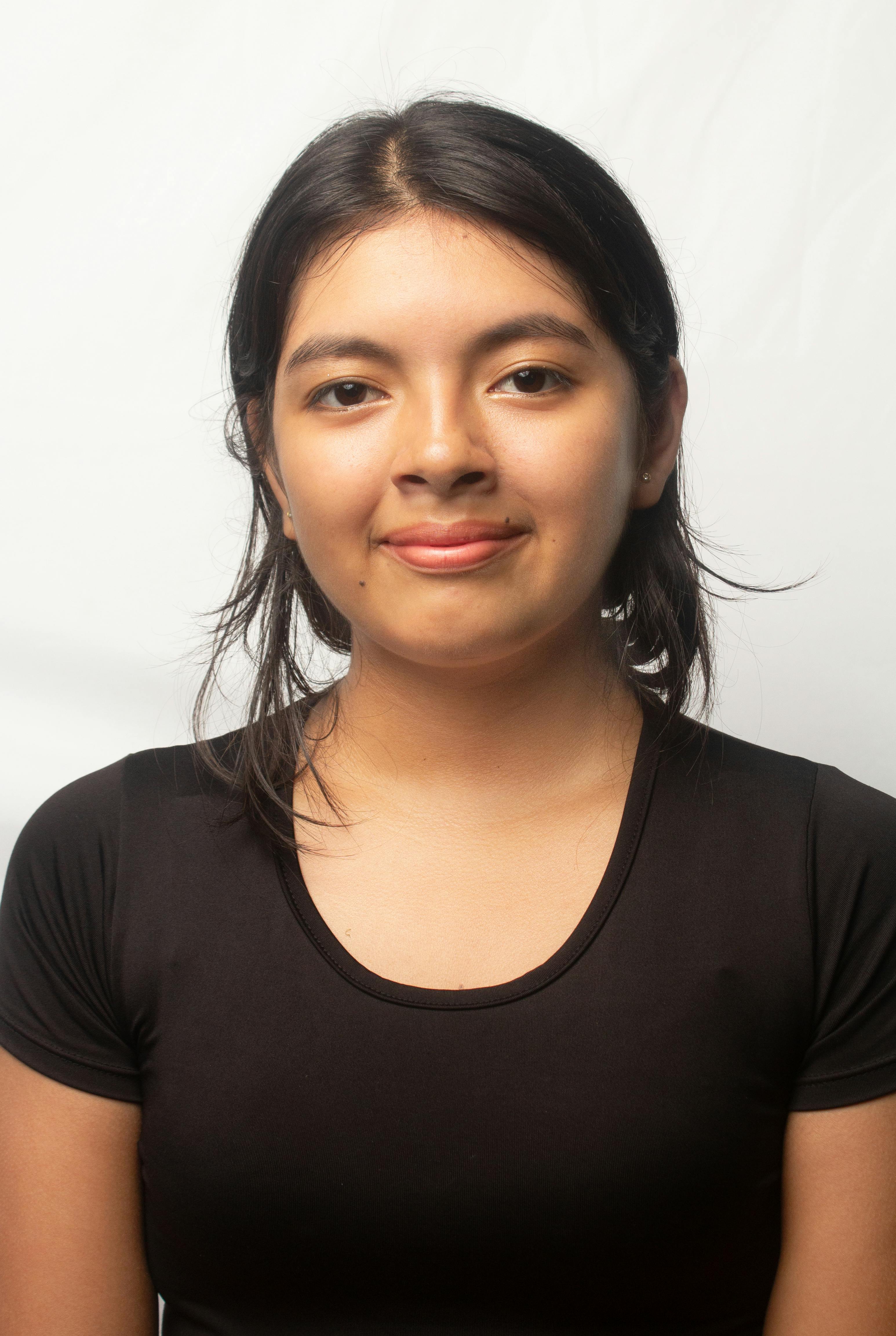 Close-up portrait of a young woman against a white background, showcasing natural beauty.