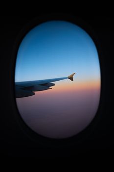 Stunning aerial view of airplane wing at sunset from window. Perfect for travel-themed content.