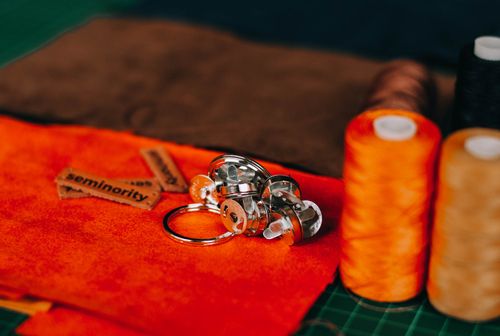 Free Vibrant orange fabric with sewing tools and threads arranged artistically for a creative flat lay. Stock Photo