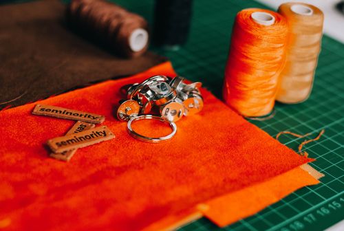 Free Vibrant sewing supplies including thread and fabric arranged on a cutting mat. Stock Photo