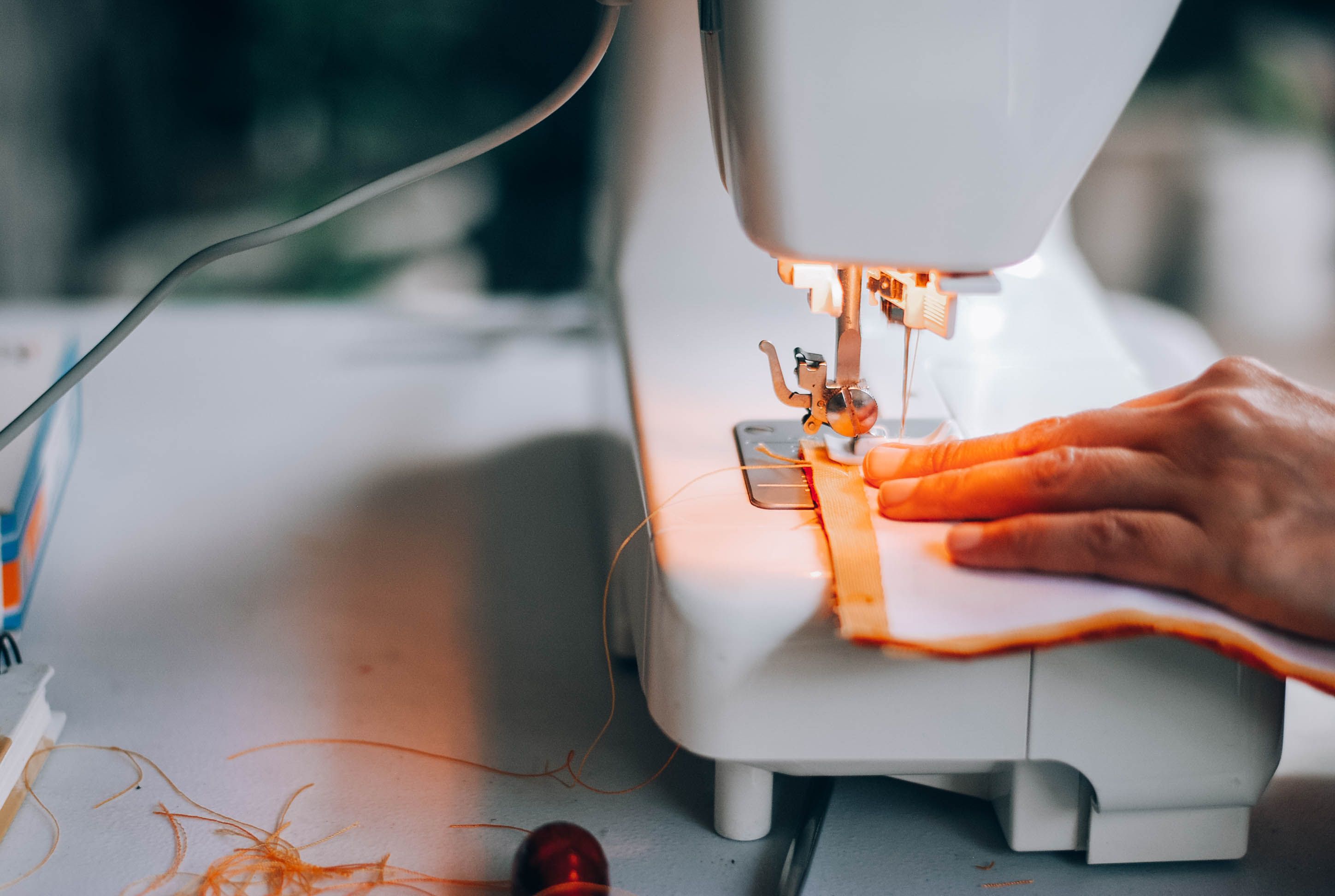 Close-up of Sewing Machine with Fabric and Hand · Free Stock Photo