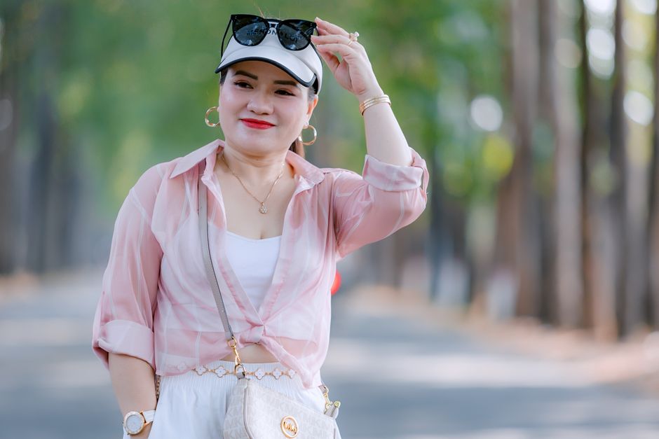 Smiling woman in casual summer attire with sunglasses outdoors.