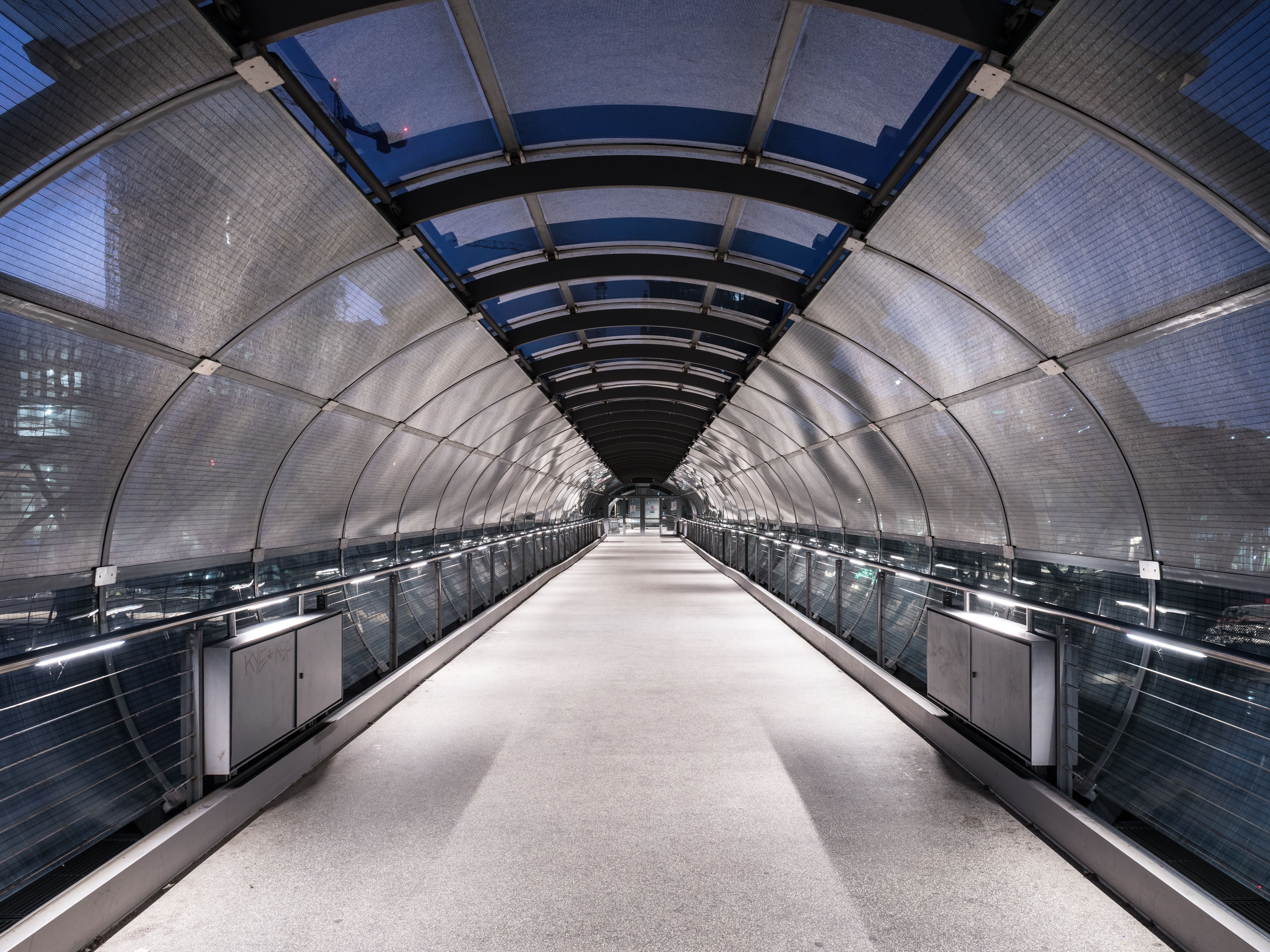 Modern and futuristic pedestrian tunnel in a Hamburg train station, showcasing architectural symmetry.