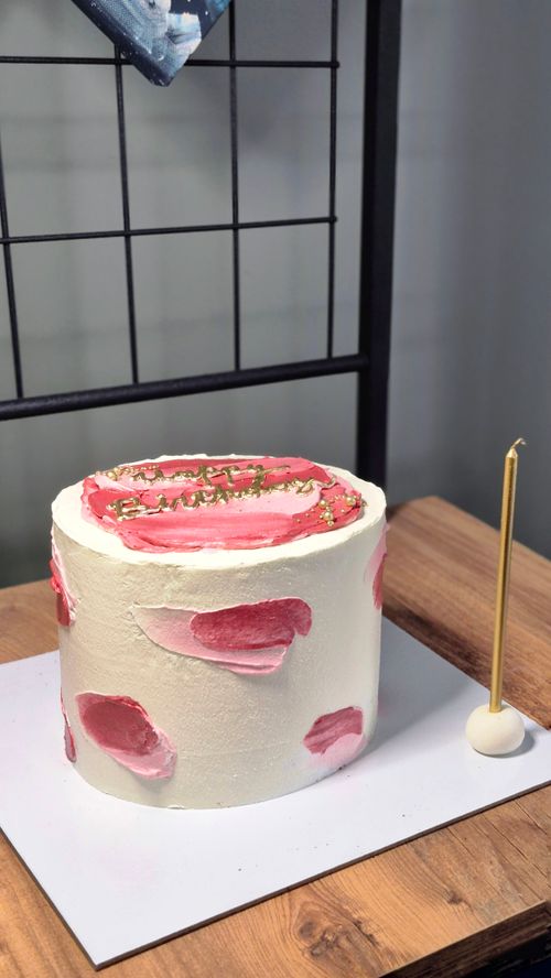 Free A beautifully decorated vanilla cake with pink buttercream and gold accents, perfect for celebrations. Stock Photo