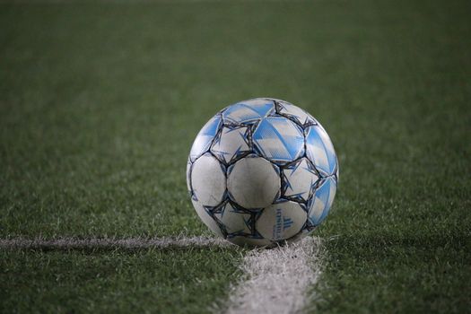 A close-up view of a soccer ball on a green field, highlighting sports theme.