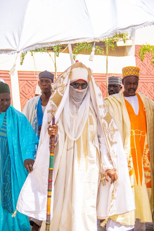 Free A group of men wearing traditional African attire during a cultural celebration outdoors. Stock Photo