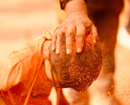 A vibrant festival scene in Nepal showing a traditional ritual with colored powder.