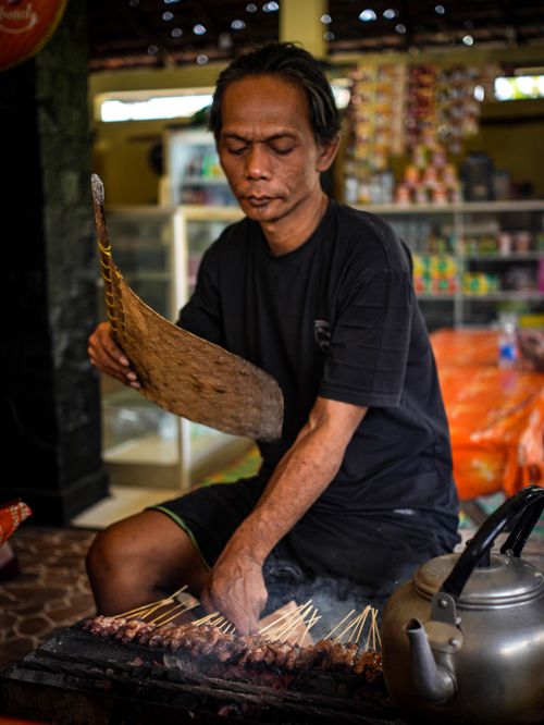 Free A street vendor fanning skewers of satay on a grill in Purwakarta, Indonesia. Stock Photo