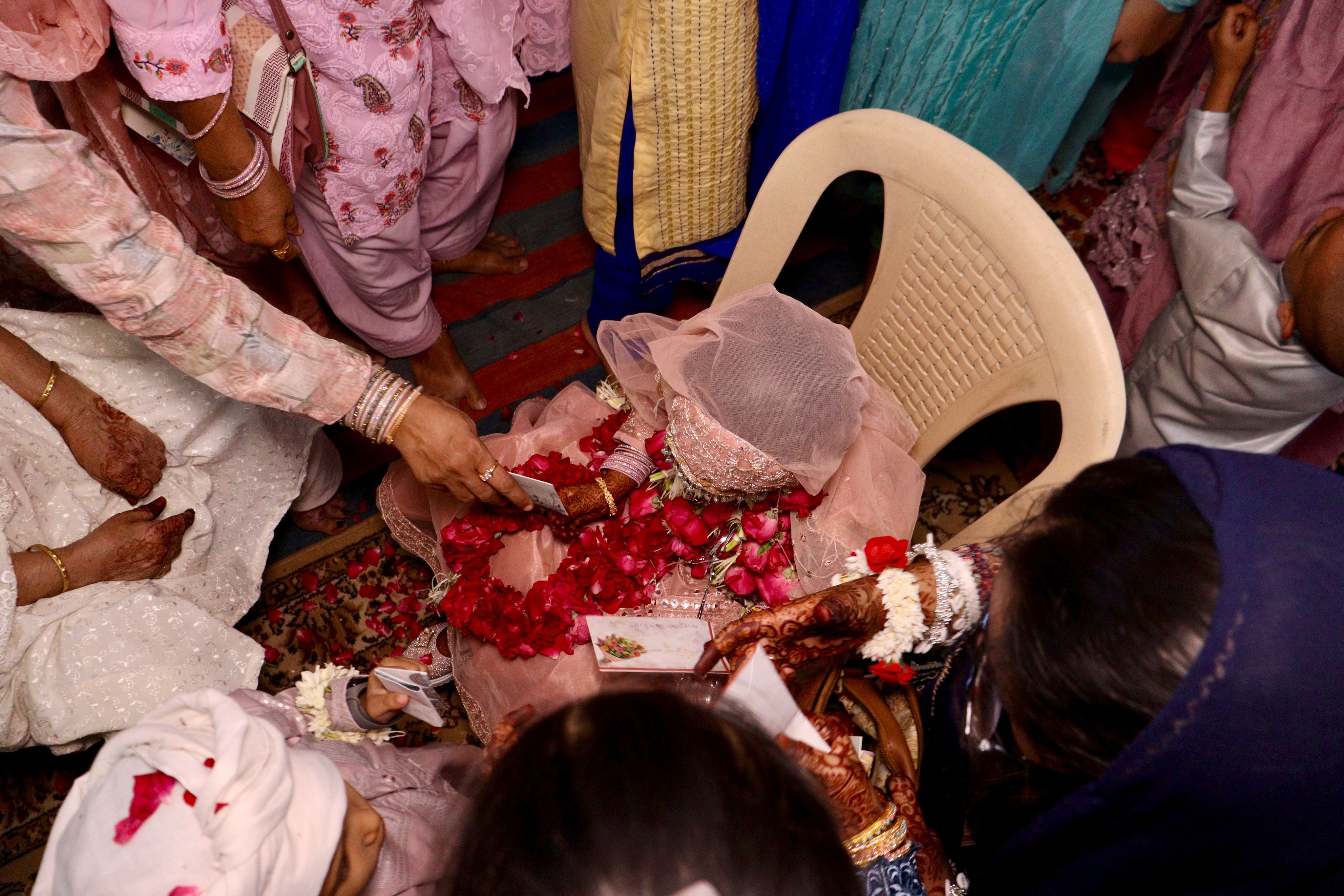 A Hindu ceremony featuring women engaged in a ritual with flowers and traditional attire.