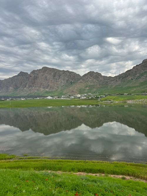 Free Dramatic landscape of lake with mountains and reflections under a cloudy sky in Iraq. Stock Photo