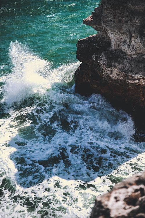 Free Powerful waves crash against rugged cliffs, creating a dramatic seascape with foamy splashes. Stock Photo