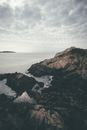 黄昏时分，云层笼罩着崎岖的沿海景观，展现着大自然的力量