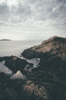 黄昏时分，云层笼罩着崎岖的沿海景观，展现着大自然的力量