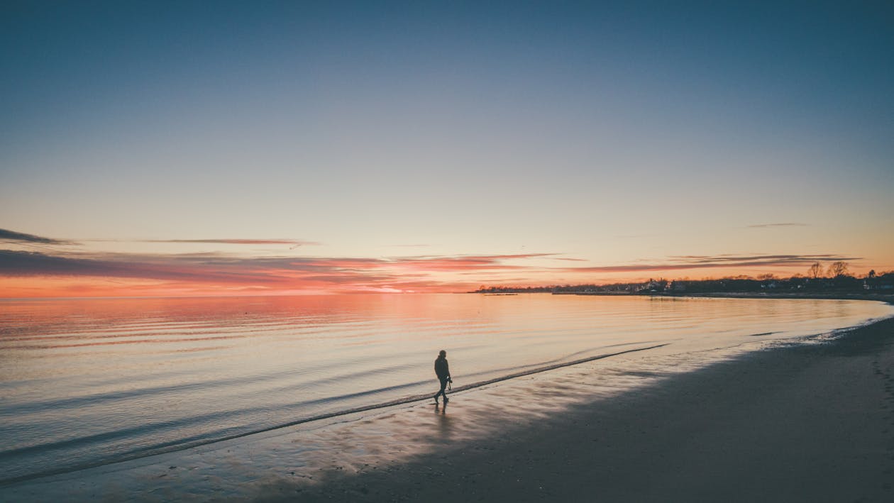 Free Person Walking At The Beach During Sunset Stock Photo