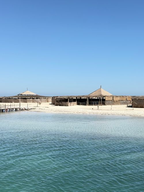 Free Sunny beachfront view with straw huts in Le Chaffar, Sfax, Tunisia. Stock Photo