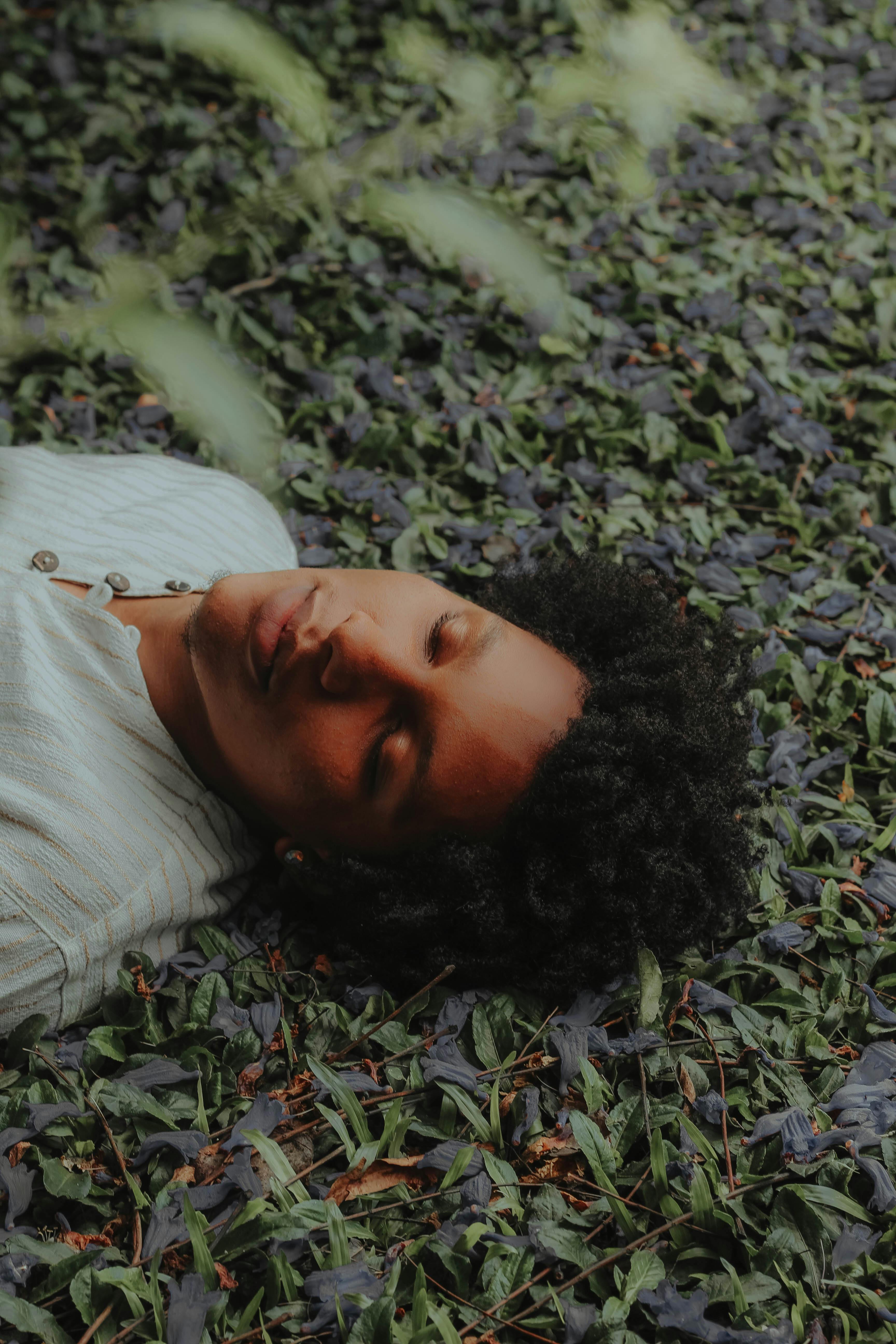 在圣保罗花园里，年轻人闭着眼睛，安详地躺在绿叶上