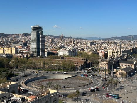 Aerial view of Barcelona showcasing urban skyline with iconic landmarks on a sunny day.