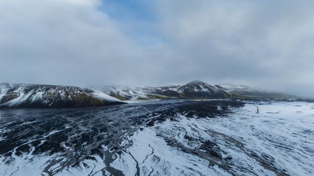 A breathtaking aerial view of snowy mountains and icy plains in Iceland, showcasing natural beauty.