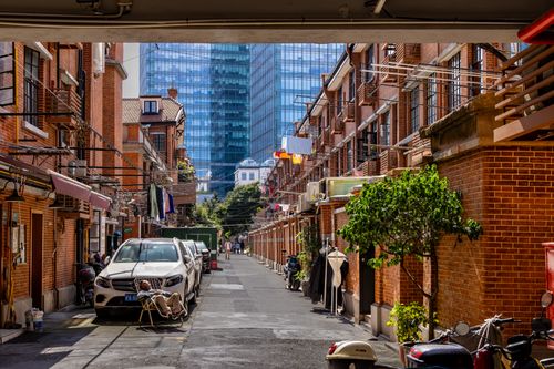 Free Vibrant city alleyway with red brick buildings and modern skyscrapers. Stock Photo