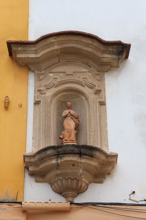 Free Stone niche featuring a religious statue in El Puerto de Santa María, Spain. Stock Photo