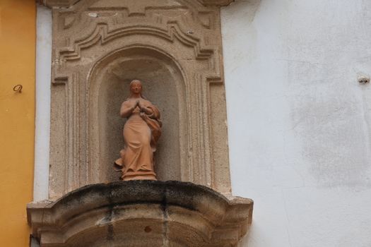 A terracotta statue in an architectural niche in El Puerto de Santa María, Spain.