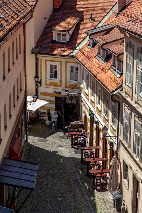 Free Explore a charming cafe alley in Maribor with outdoor seating and historic architecture. Stock Photo