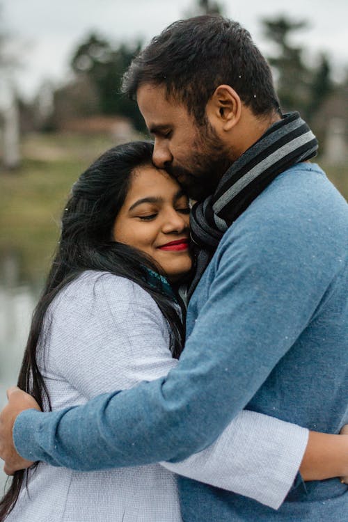 Free Man In Blue Kissing Woman On Forehead Stock Photo