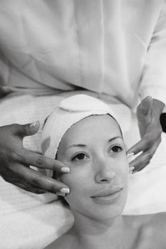 A woman enjoying a relaxing facial massage in a tranquil spa environment.