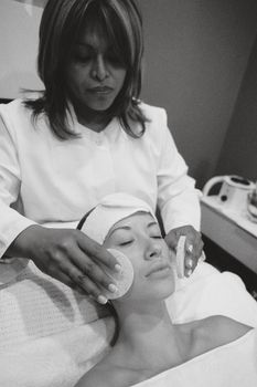 A beautician performing a facial treatment in a spa. Relaxing skincare experience.
