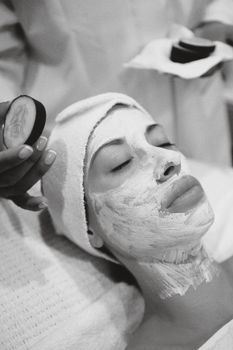 A serene spa experience featuring a woman receiving a rejuvenating facial mask, promoting skincare and relaxation.
